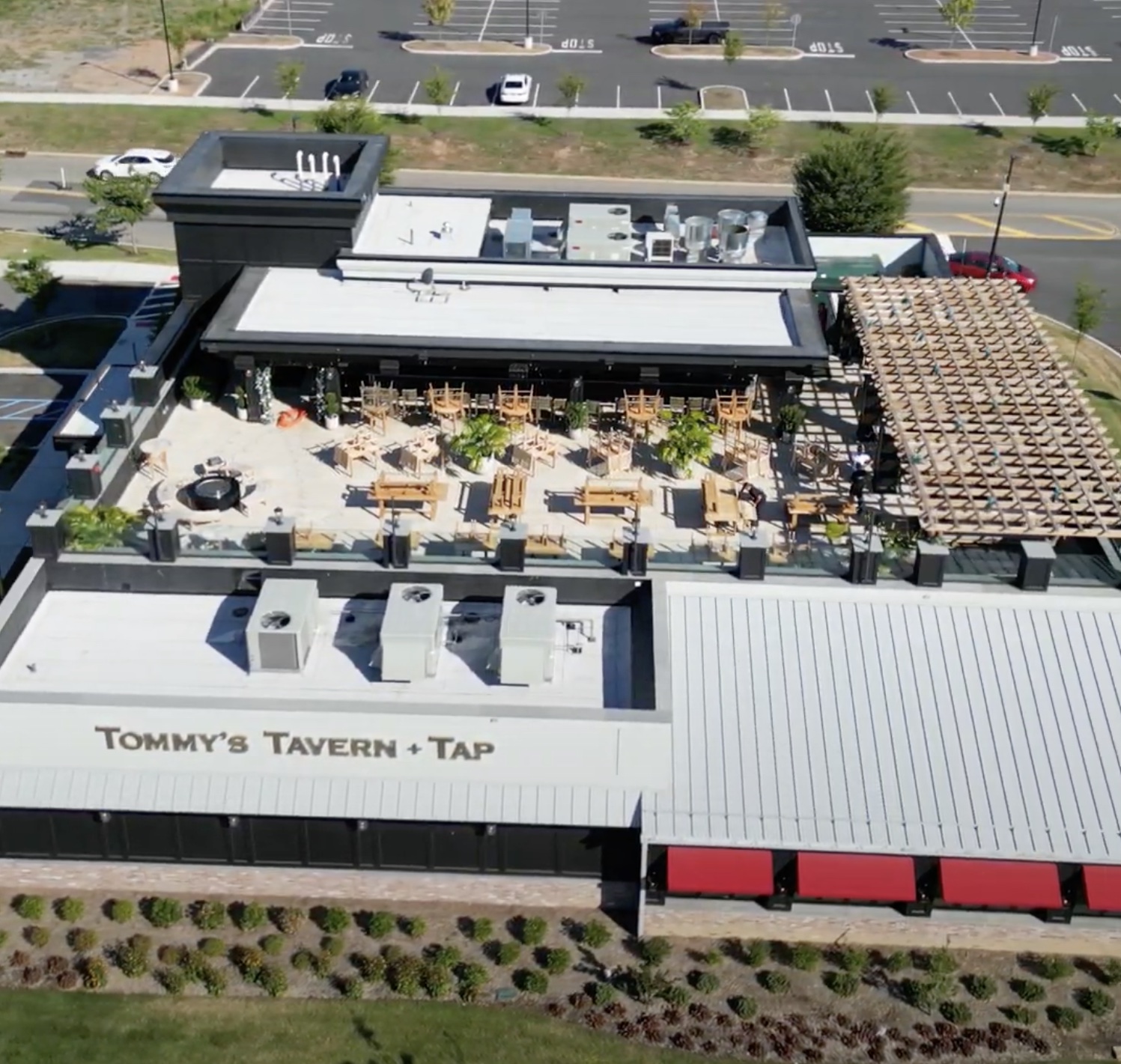 Aerial view of Tommy's Tavern & Tap Edison rooftop showing the dining area, lounge with fire feature, and the corner bar