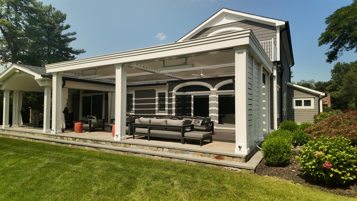 Transitional louvered pergola attached to a home in Manhasset, NY