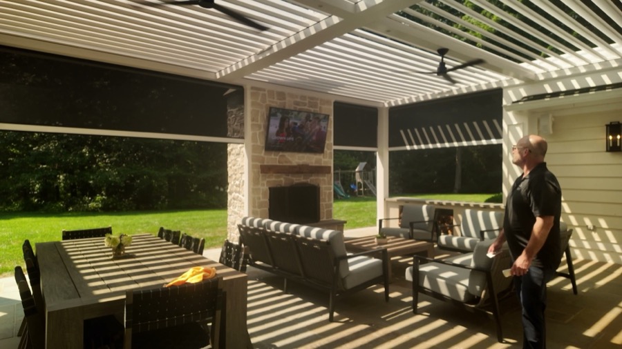 Louvered pergola with motorized screens lowered along the open sides